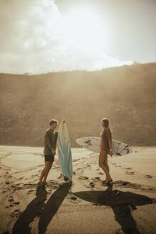 Couple preparing to surf while holding the boards. Tenerife, Canary Islands, Spain - ACPF01588