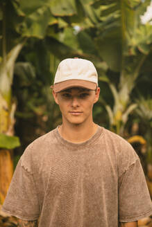 Boy with a cap in front of some banana trees looking at the camera. Tenerife, Canary Islands, Spain - ACPF01598