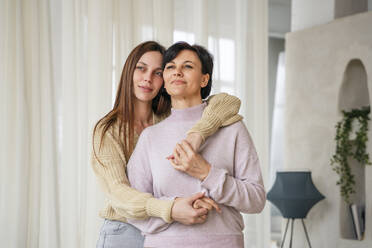 Smiling woman embracing mother at home - NLAF00422