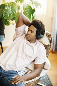 young man in casual clothes, relaxing while listening music - FLMZF00054