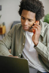 young handsome man having a phone call in home office - FLMZF00085