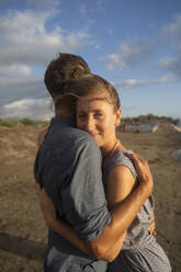 Smiling woman embracing man at beach - NJAF00958