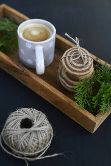 Cookies, fir tree twigs and mug of coffee on wooden tray - GISF01067