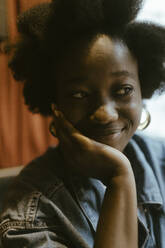 Smiling young woman leaning on elbow at restaurant - MASF44016