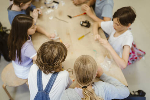 High angle view of male and female students working on robotics project at school - MASF44137