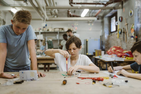 Jungen arbeiten an einem Robotikprojekt in der Werkstatt der Schule - MASF44146