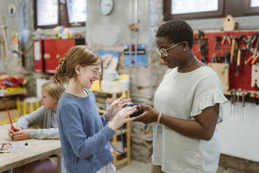 Eine Lehrerin erklärt einem Schüler in einem Technik-Workshop in der Schule ein elektrisches Bauteil - MASF44150