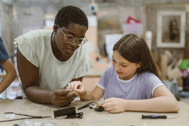 Lehrerin hilft Schülerin bei der Arbeit an einem Robotikprojekt im Technikunterricht in der Schule - MASF44165