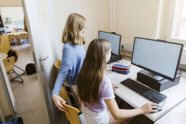 Female students surfing internet on computer at desk in classroom - MASF44166