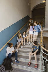 Männliche und weibliche Schüler auf der Treppe in der Schulpause - MASF44232