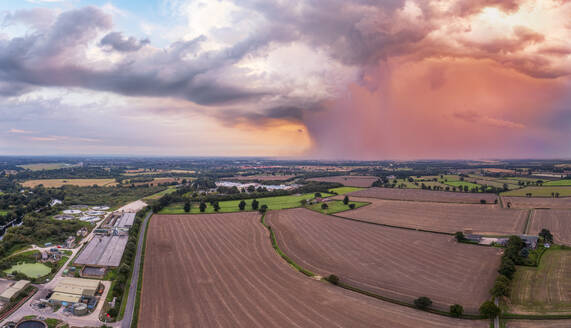 UK, England, York, Luftaufnahme von gepflügten Feldern mit Gewitterwolken im Hintergrund - SMAF02773