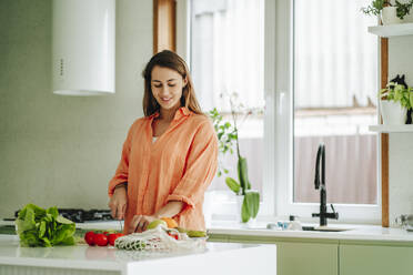 Russia. Woman chopping fruits in the kitchen - OLRF00264