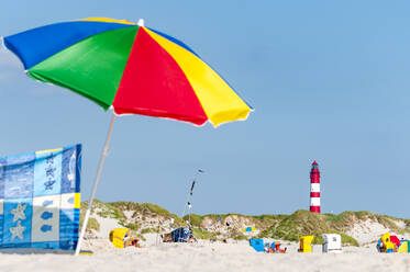 Deutschland, Schleswig-Holstein, Amrum, Sandstrand mit buntem Sonnenschirm im Vordergrund - EGBF01075