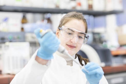 Fokussierter Wissenschaftler, der ein Reagenzglas in einer Laborumgebung untersucht. - ISF26553