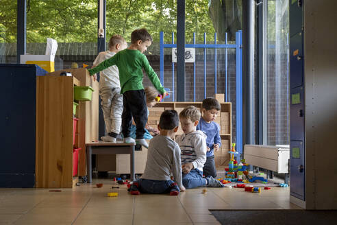 Kinder spielen zusammen in einem bunten Spielzimmer - ISF26583