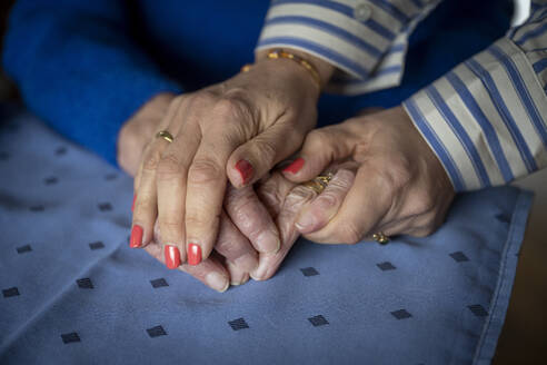 Two elderly ladies holding hands close up - ISF26834