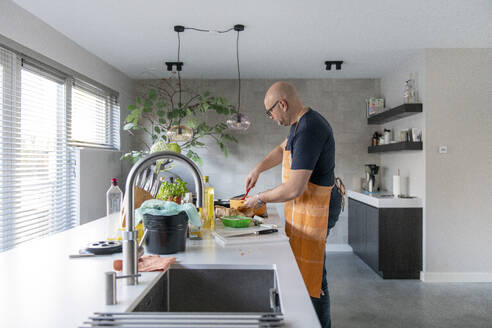 Adult man preparing mince for a lasagne in his modern kitchen - ISF26921