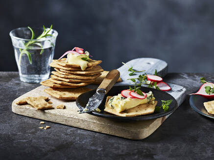 Savory pancakes served with a dollop of herb butter on a rustic wooden board - ISF26991