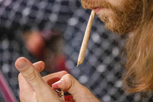 Closeup of a man smoking at night, illuminated by city lights. - ISF27056