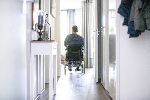 Mann im Rollstuhl verlässt das Haus, um einkaufen zu gehen - ISF27125