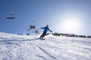 Adventurous man skiing down a slope in winter gear. - ISF27154