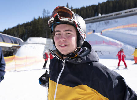 Young attractive man in ski gear at the bottom of a slope. happy and smiling - ISF27155