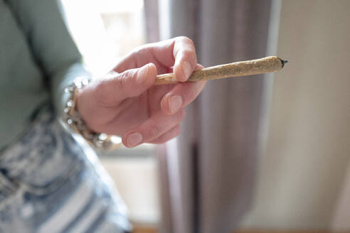 Hands of a woman holding a marijuana joint - ISF27190