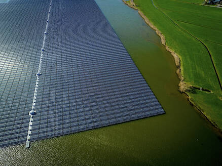Aerial view of a solar farm next to a body of water - ISF27304