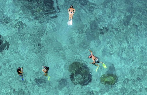 Aerial view of a adult white man woman swimming tropical island west of Lombok. It is part of the Indonesian island group, the Gili Islands. - ISF27313